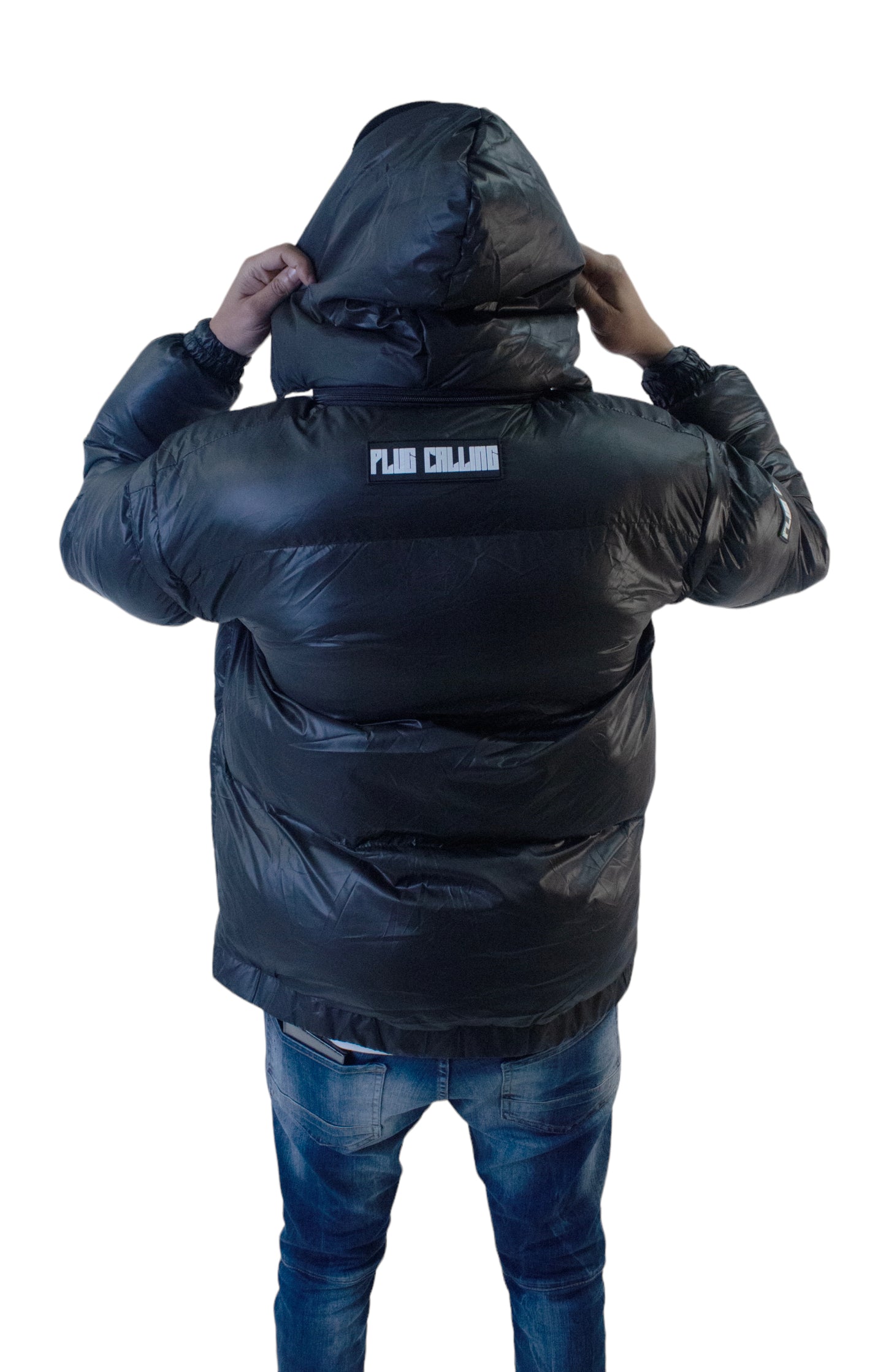 "Back view of black hooded puffer jacket, showcasing Plug Calling branding, highlighting streetwear trends by an empowering unisex fashion brand."