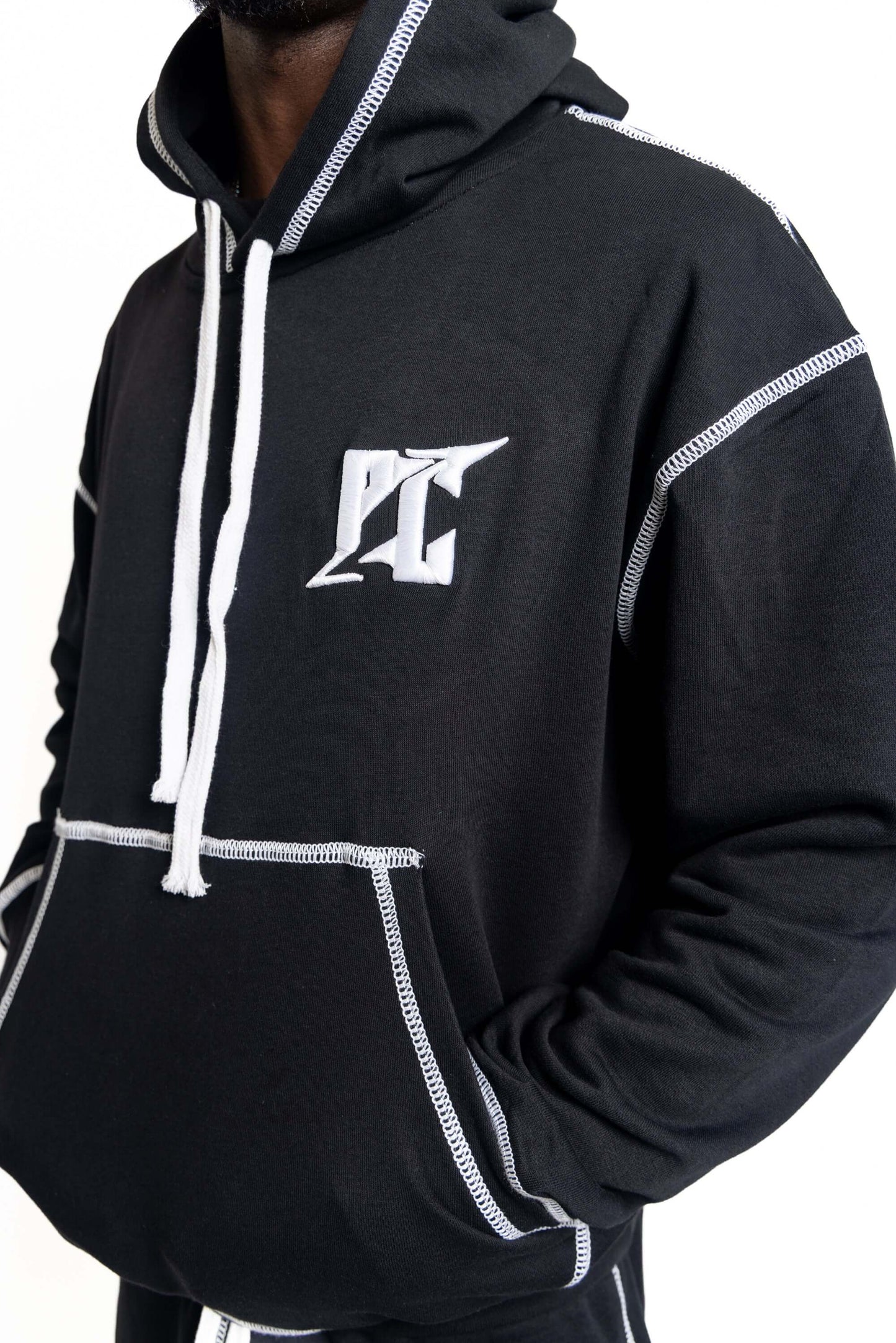 Person wearing contrast-stitch shorts set hoodie with white stitching, showcasing a modern streetwear style.